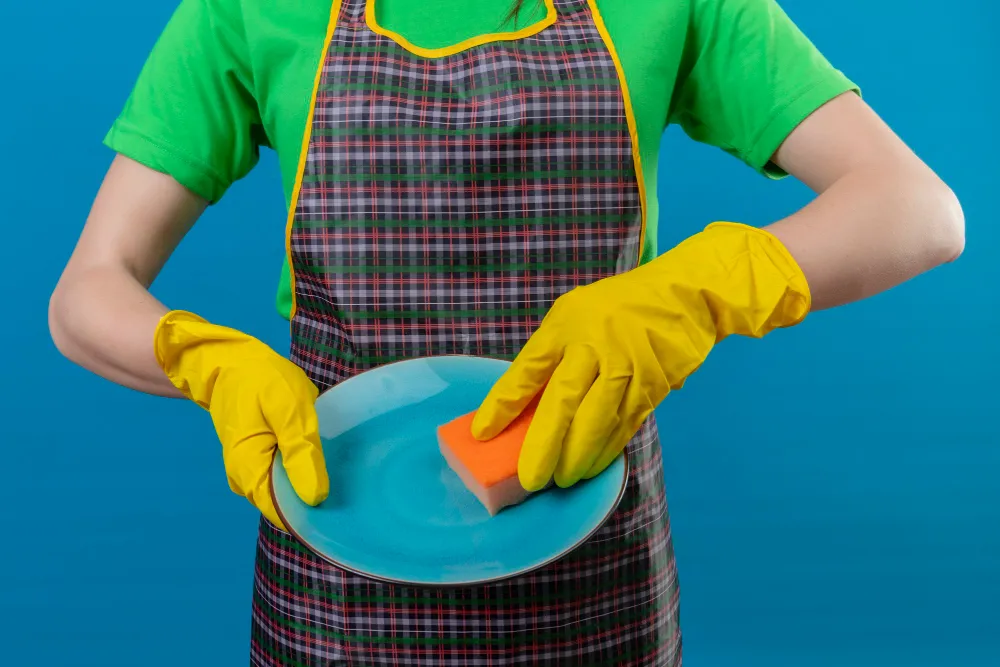 شخص ينظف الطبق بليفة الجلي