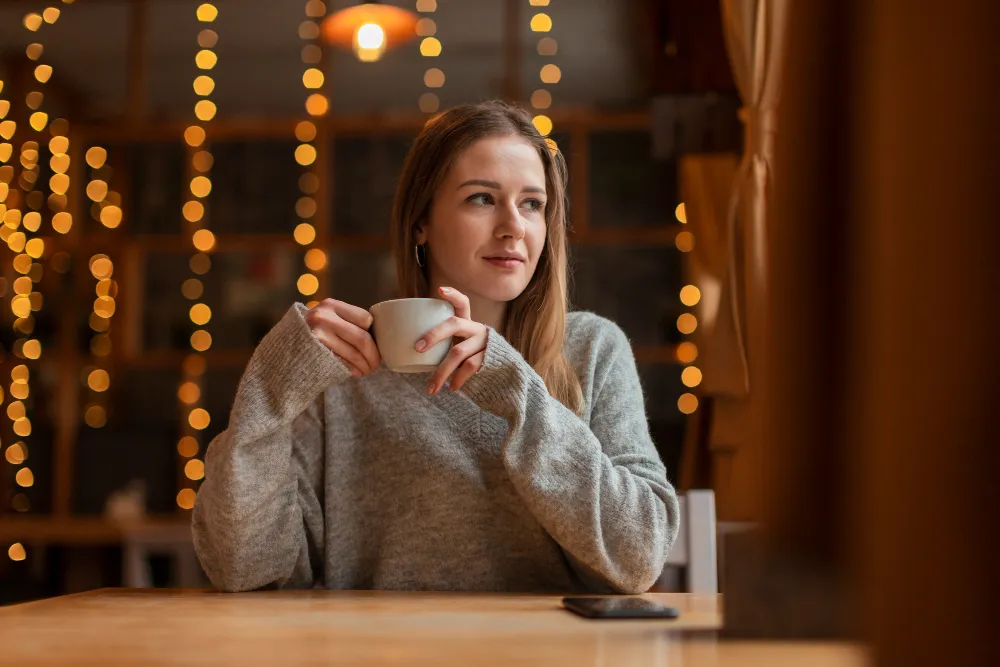 امرأة تشرب مشروبًا دافئًا