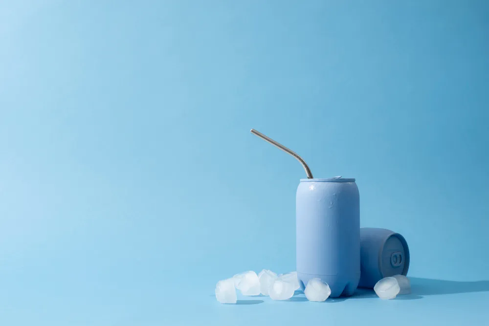 علب مشروبات مع قطع من الثلج